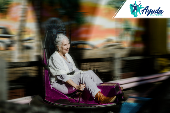 An elderly woman smiles while enjoying a ride at an amusement park, symbolizing both the joy and risks associated with theme park attractions. The image relates to the injury settlement awarded after a fall at Universal Studios Hollywood, as reported by Ayuda California.